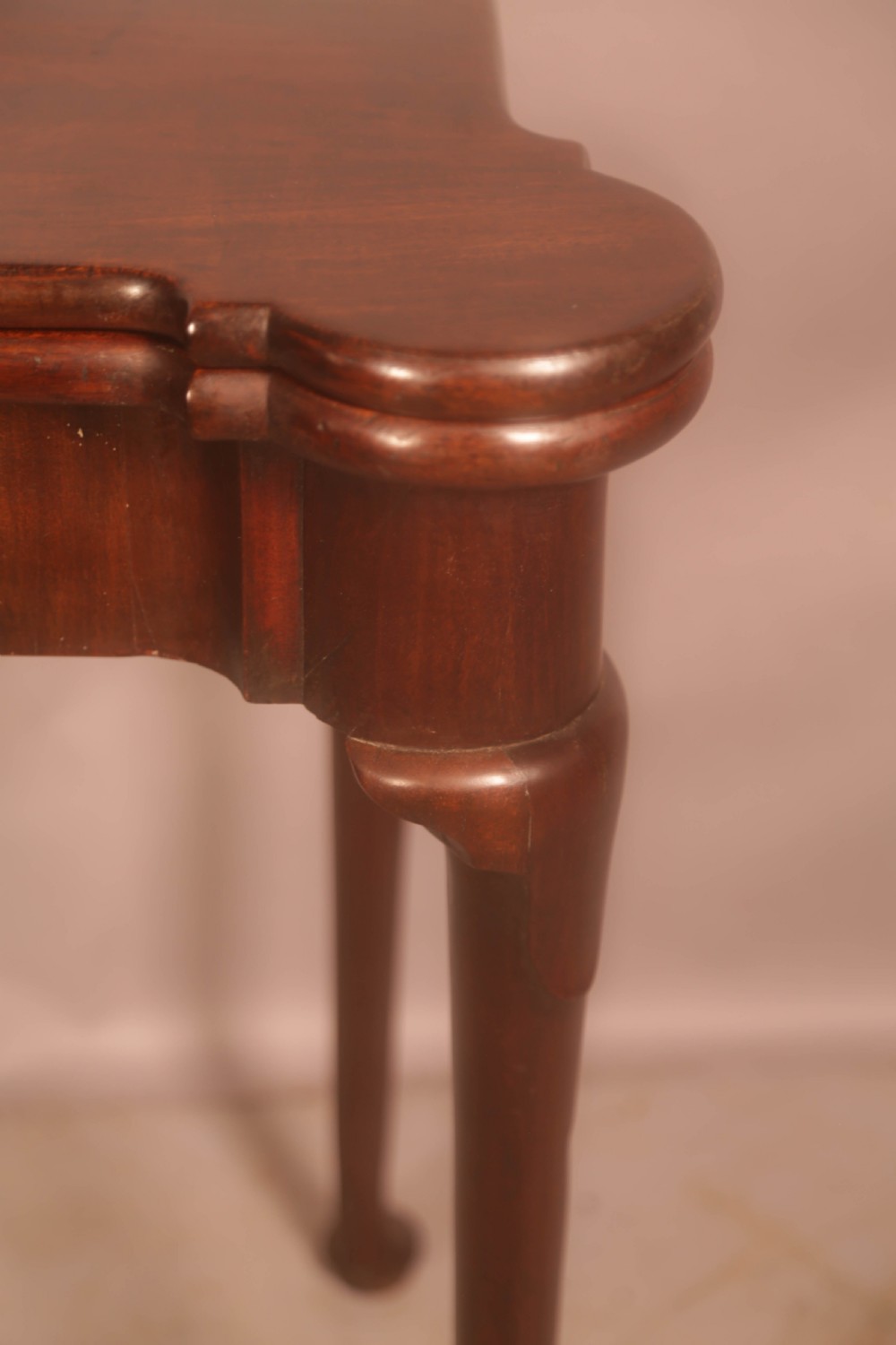 A mid-18th century Georgian mahogany fold-over card table featuring projecting rounded corners, a smooth apron, and slender cabriole legs terminating in pad feet. View XI