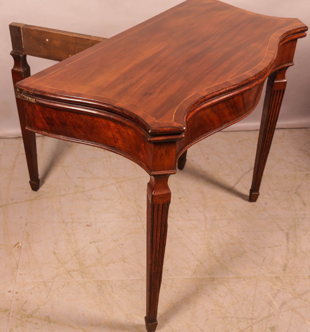 An 18th-century Georgian mahogany games table featuring a serpentine-curved folding top and fluted tapered legs. View VIII