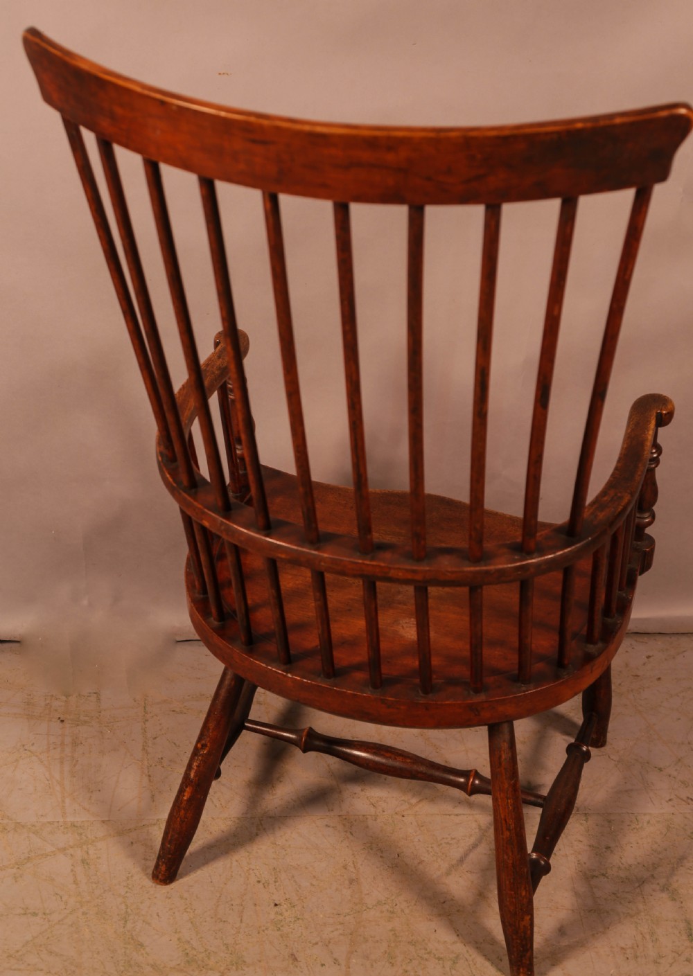 A high-back Scottish Darvel Windsor armchair crafted from warm brown wood, featuring a comb crest rail, spindle back, curved arm bow, and saddle seat. View III