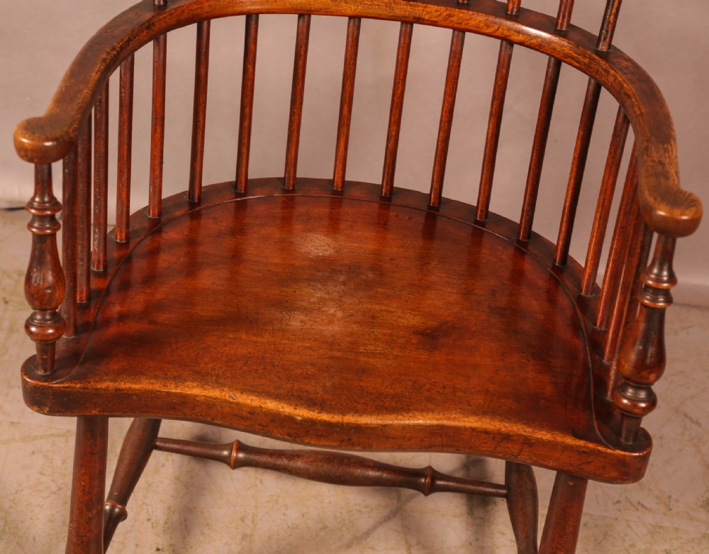 A high-back Scottish Darvel Windsor armchair crafted from warm brown wood, featuring a comb crest rail, spindle back, curved arm bow, and saddle seat. View V