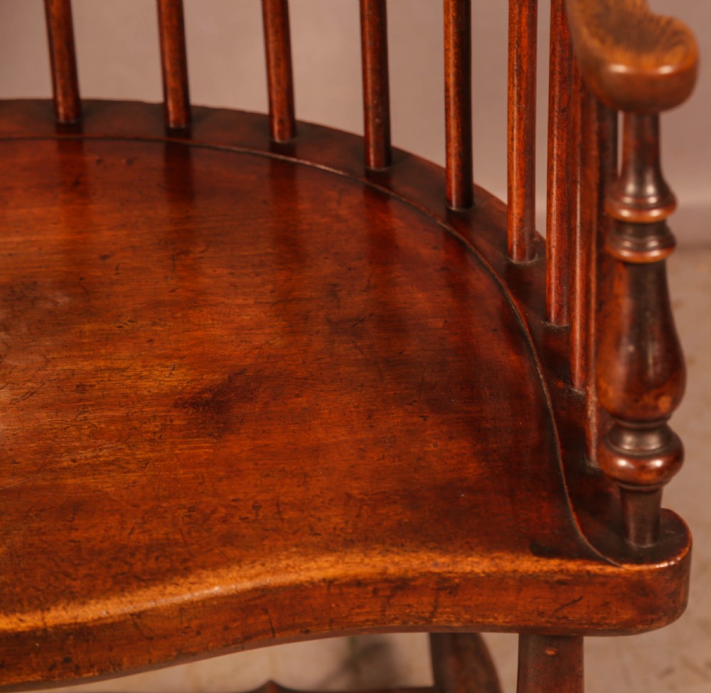 A high-back Scottish Darvel Windsor armchair crafted from warm brown wood, featuring a comb crest rail, spindle back, curved arm bow, and saddle seat. View VI