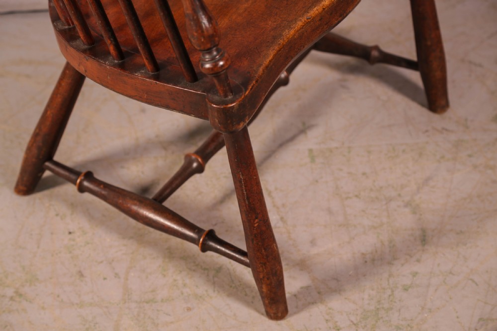 A high-back Scottish Darvel Windsor armchair crafted from warm brown wood, featuring a comb crest rail, spindle back, curved arm bow, and saddle seat. View X