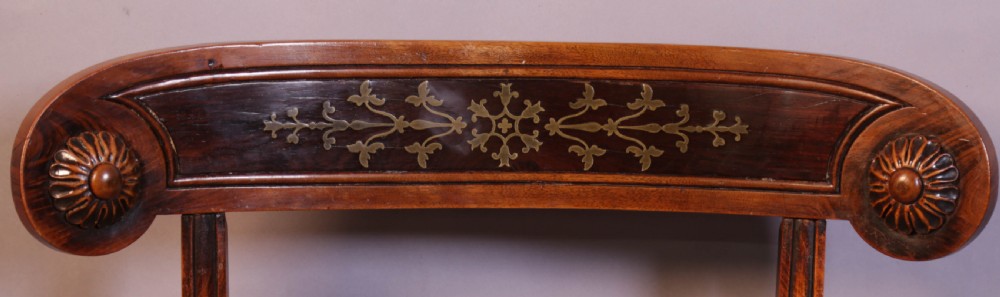 A set of four Regency rosewood dining chairs featuring brass inlay on the curved crest rails, carved splats, reeded front legs, and patterned red seats. View VII