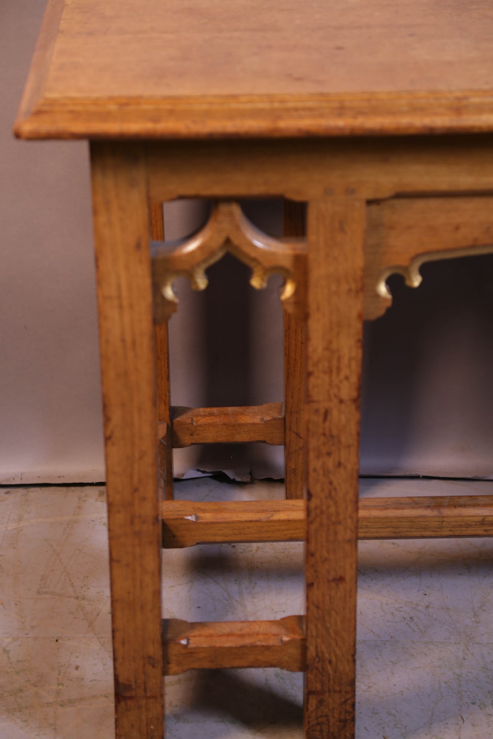 A 19th-century oak Gothic Revival serving table featuring carved pointed arch spandrels and a low box stretcher. View IV