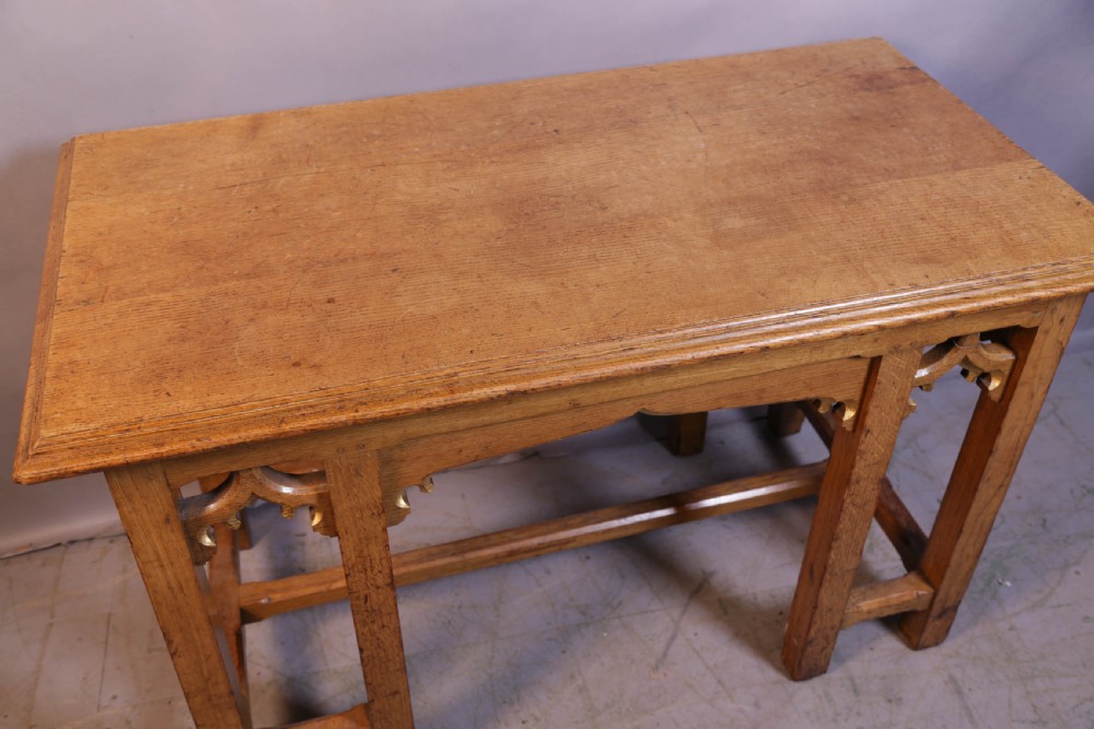 A 19th-century oak Gothic Revival serving table featuring carved pointed arch spandrels and a low box stretcher. View V