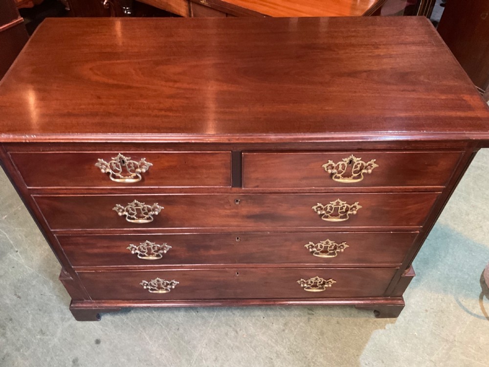 A Georgian mahogany chest of drawers featuring a two-over-three drawer arrangement, ornate brass swan-neck handles, and bracket feet. View VII