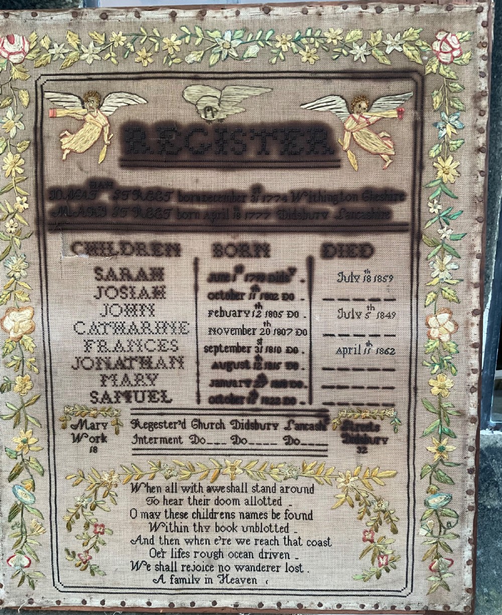 An 1832 Georgian embroidered linen needlework sampler featuring a family register, verse, winged figures, and a floral border.