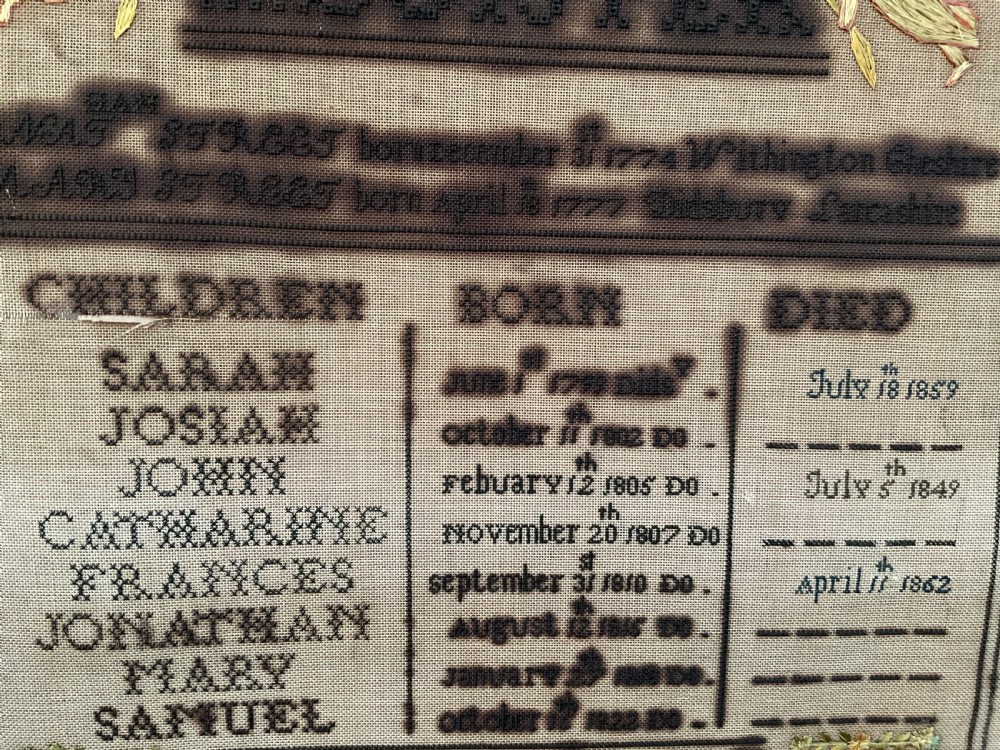 An 1832 Georgian embroidered linen needlework sampler featuring a family register, verse, winged figures, and a floral border. View XIV