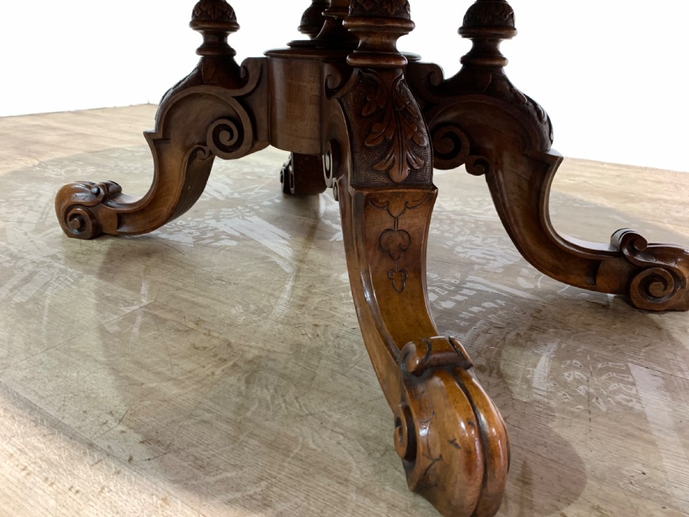 An oval Victorian coffee table featuring a highly figured burr walnut top and scrolled carved legs. View VII