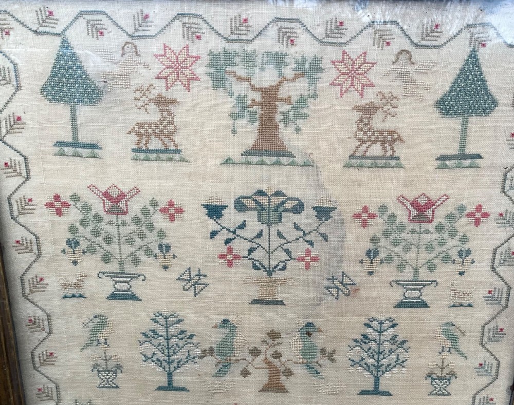 A framed antique needlework sampler on cream linen featuring embroidered trees, stags, flowers, a central windmill, a poetic verse, and the makers signature Mary Mason Aged 12. View III