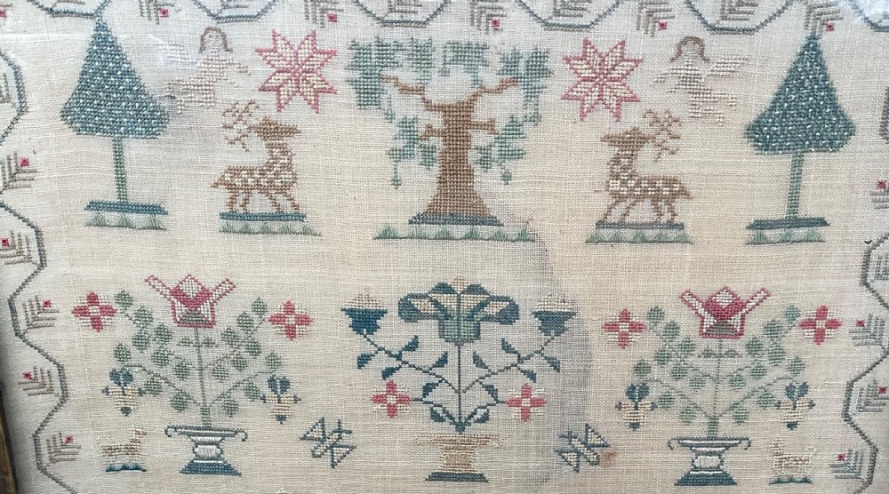 A framed antique needlework sampler on cream linen featuring embroidered trees, stags, flowers, a central windmill, a poetic verse, and the makers signature Mary Mason Aged 12. View V