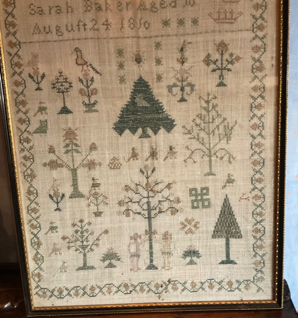 A framed 1810 Georgian linen sampler featuring hand-stitched religious verse, tree motifs, geometric borders, and text reading Sarah Baker Aged 10 August 24 1810. View III