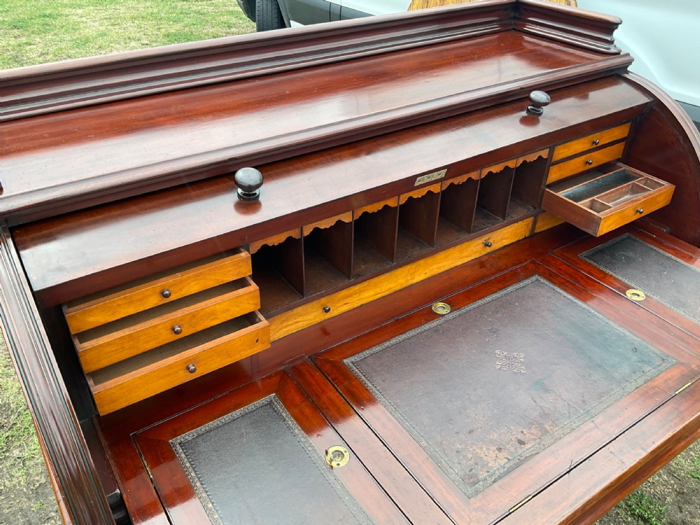 A 19th-century dark mahogany cylinder desk featuring a curved roll-top cover above twin drawer pedestals. View XVIII