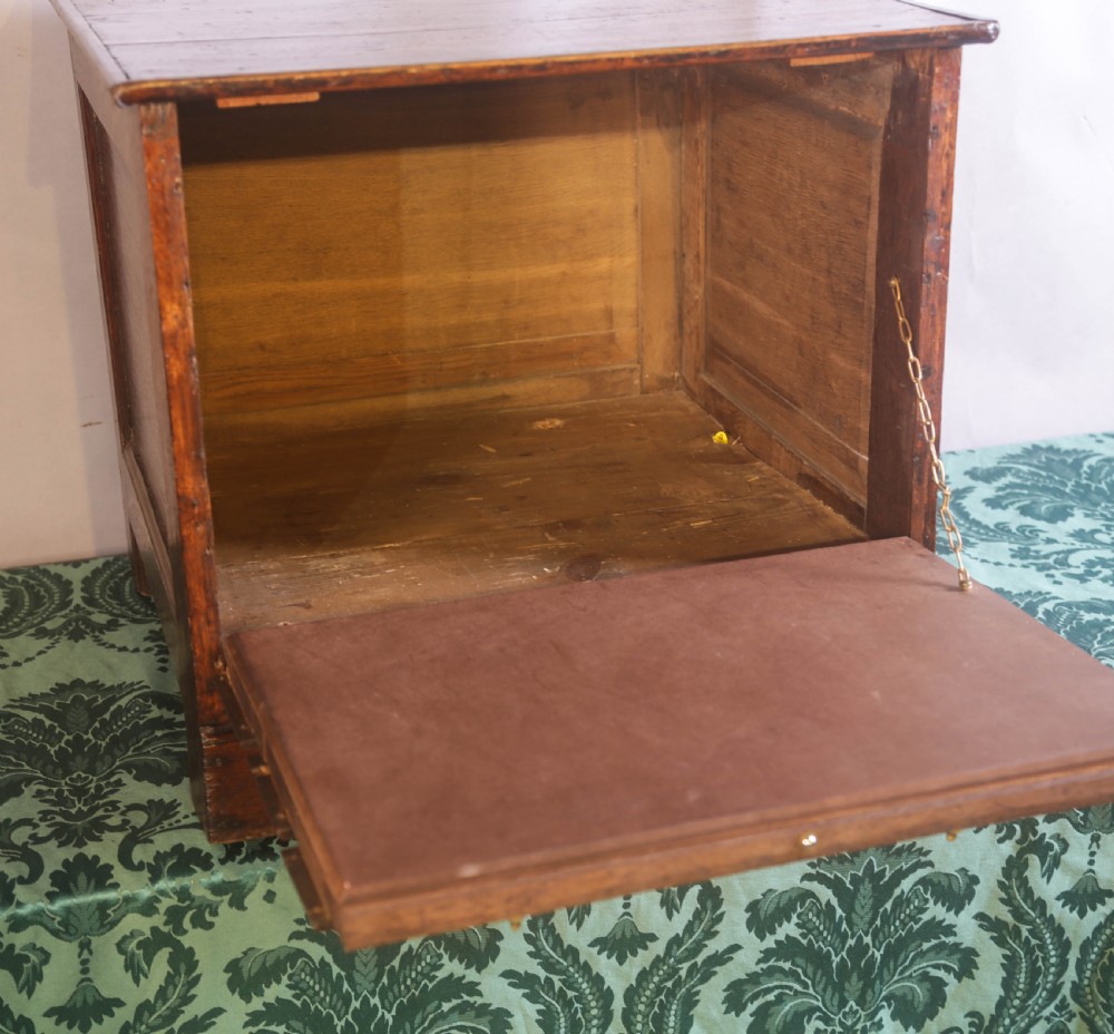 A small Georgian oak chest of drawers featuring brass drop handles, keyhole escutcheons, and a shaped apron with bracket feet. View IV