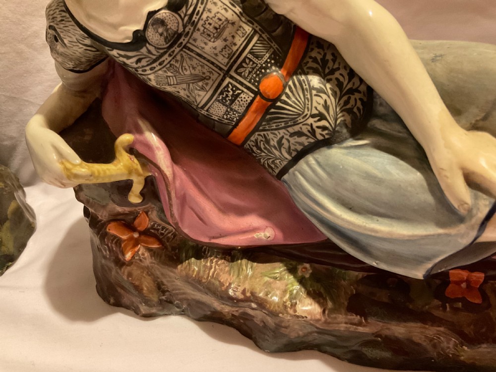 A pair of antique ceramic reclining figures depicting Mark Antony and Cleopatra on moulded bases. View IV