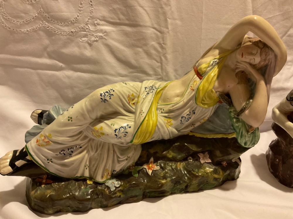 A pair of antique ceramic reclining figures depicting Mark Antony and Cleopatra on moulded bases. View VI
