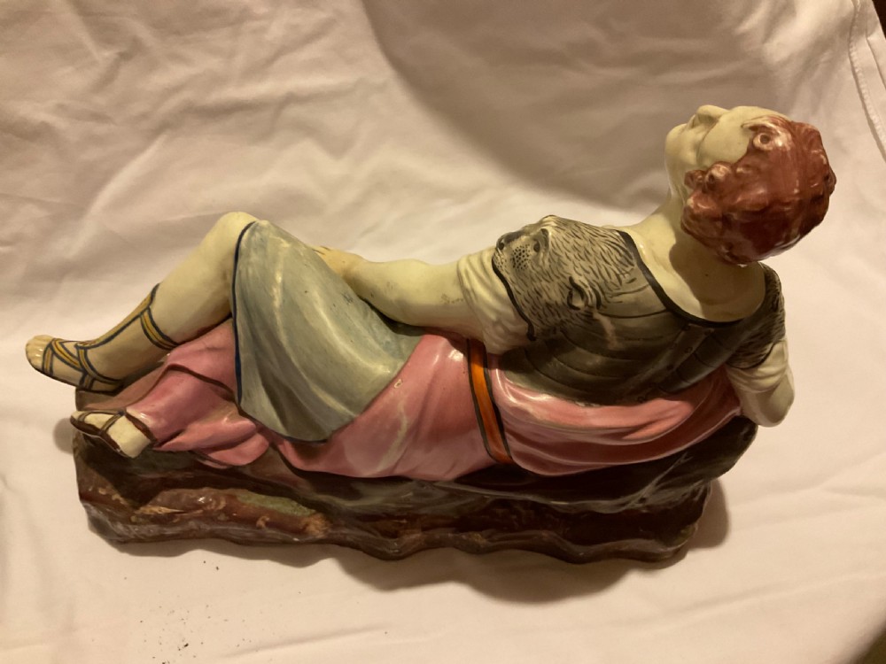 A pair of antique ceramic reclining figures depicting Mark Antony and Cleopatra on moulded bases. View X