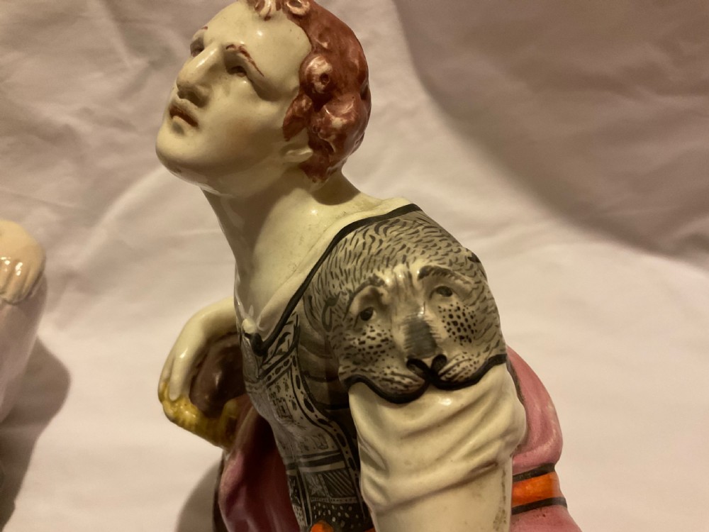 A pair of antique ceramic reclining figures depicting Mark Antony and Cleopatra on moulded bases. View XII
