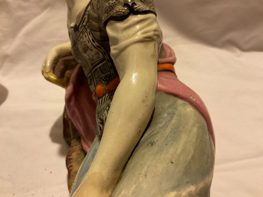 A pair of antique ceramic reclining figures depicting Mark Antony and Cleopatra on moulded bases. View XV