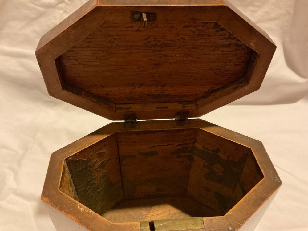An octagonal Georgian yew wood tea caddy featuring an acorn inlay on the front panel and a bone keyhole escutcheon. View IX