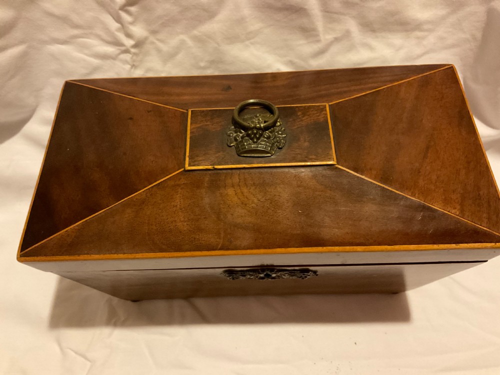 A tapered Georgian mahogany tea caddy with boxwood stringing, top brass handle, and decorative brass keyhole escutcheon. View II