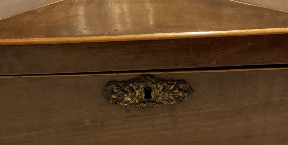 A tapered Georgian mahogany tea caddy with boxwood stringing, top brass handle, and decorative brass keyhole escutcheon. View III