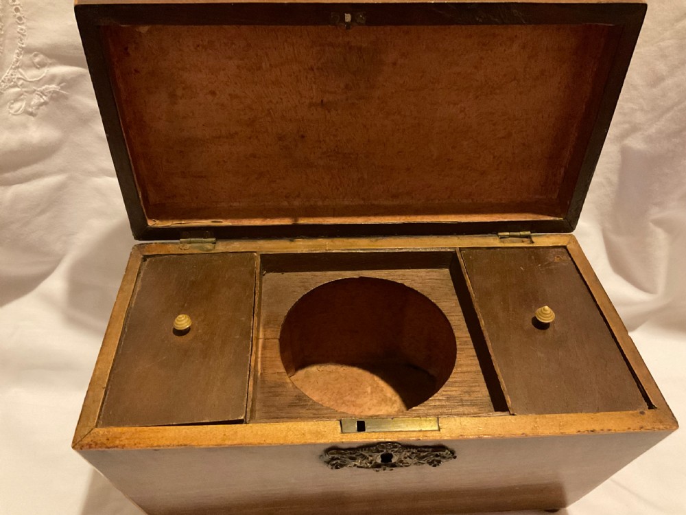 A tapered Georgian mahogany tea caddy with boxwood stringing, top brass handle, and decorative brass keyhole escutcheon. View VI