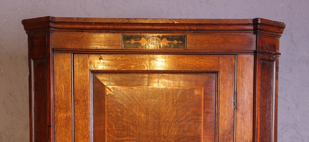 An eighteenth-century oak corner cupboard featuring a single panelled door with crossbanded inlay, a top marquetry motif, and a diamond keyhole. View III