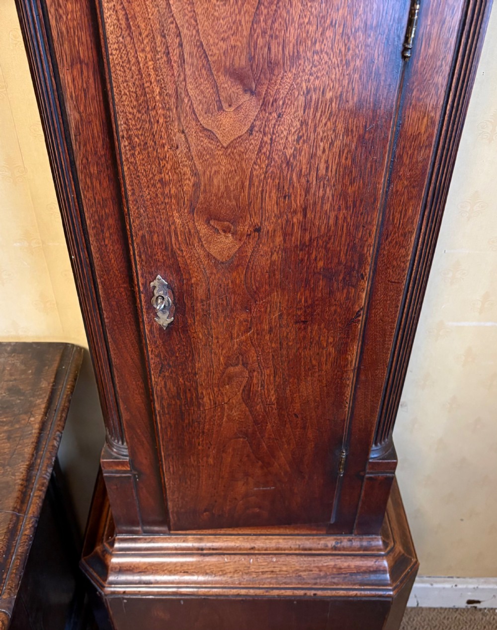 A Georgian mahogany longcase clock featuring a swan-neck pediment, fluted hood columns, and an engraved brass dial. View III