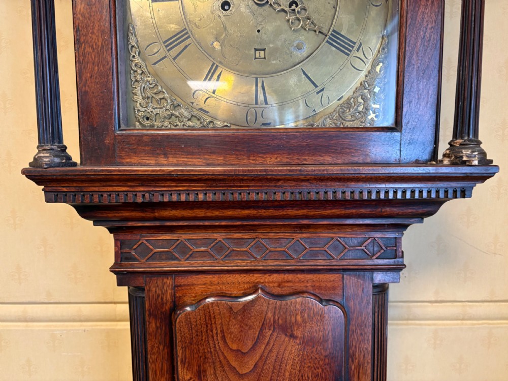 A Georgian mahogany longcase clock featuring a swan-neck pediment, fluted hood columns, and an engraved brass dial. View IV