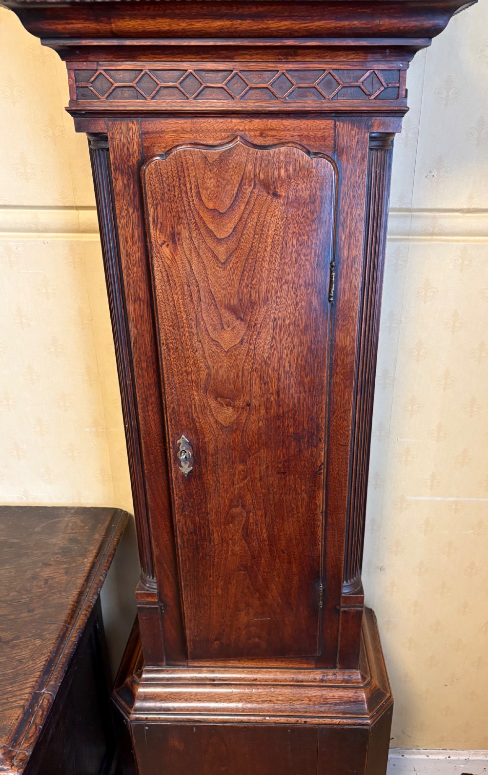 A Georgian mahogany longcase clock featuring a swan-neck pediment, fluted hood columns, and an engraved brass dial. View V