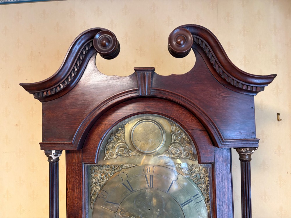 A Georgian mahogany longcase clock featuring a swan-neck pediment, fluted hood columns, and an engraved brass dial. View VI