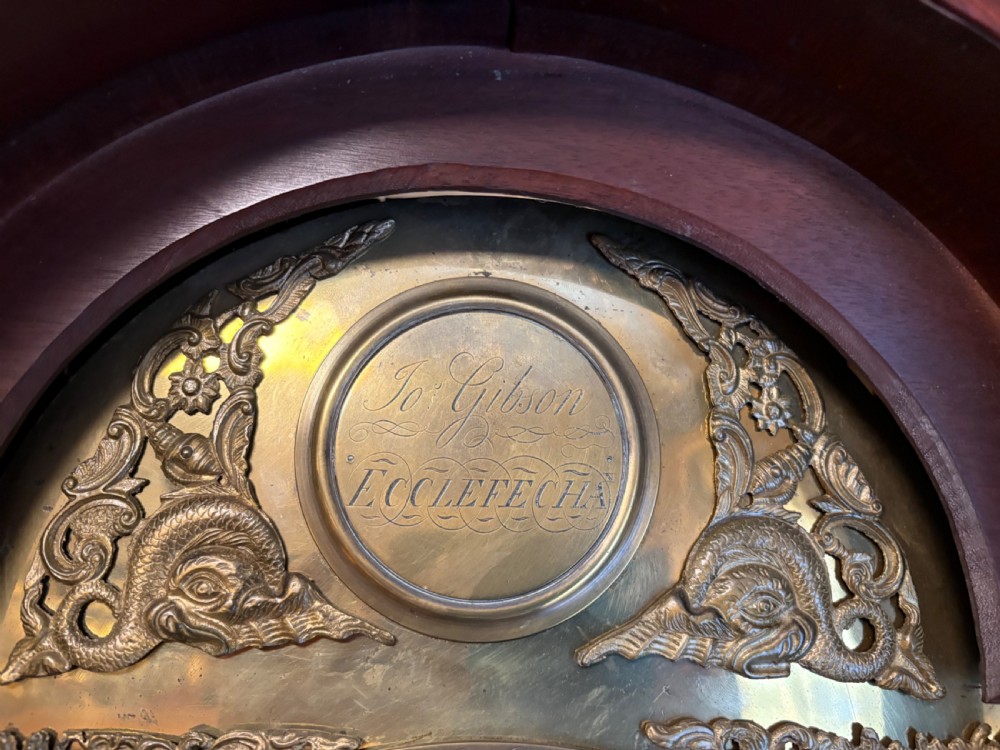A Georgian mahogany longcase clock featuring a swan-neck pediment, fluted hood columns, and an engraved brass dial. View VII