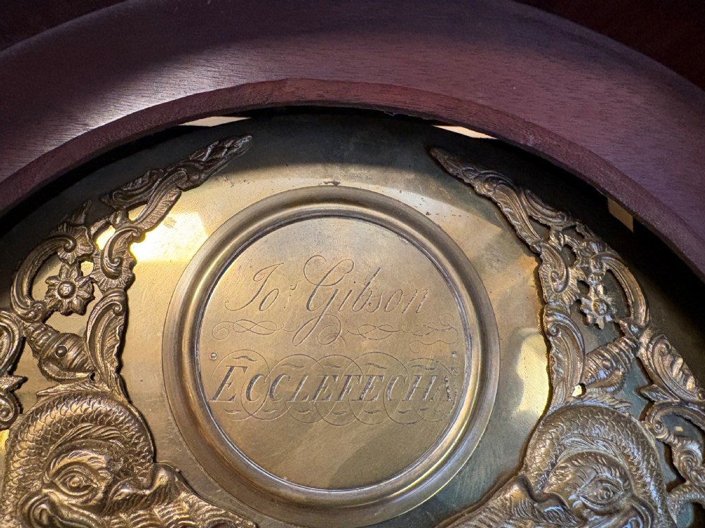 A Georgian mahogany longcase clock featuring a swan-neck pediment, fluted hood columns, and an engraved brass dial. View X