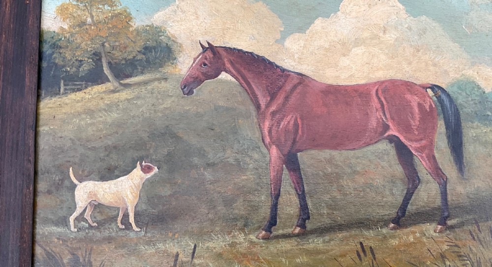 An antique oil painting depicting a chestnut horse standing alongside a small white terrier in a grassy landscape within a dark wooden frame. View V