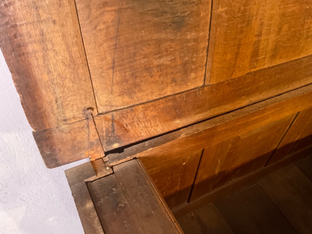 A seventeenth-century dark oak coffer featuring a framed panel lid and three front panels carved with geometric lozenge patterns. View IV