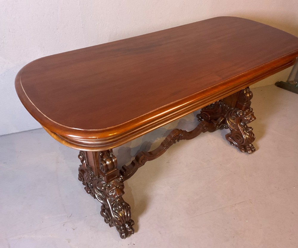 A Victorian three-tiered mahogany metamorphic dumb waiter featuring rounded shelf edges and carved scroll feet. View III