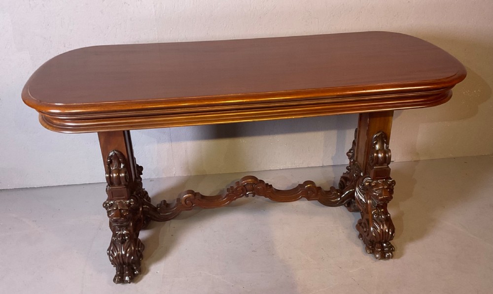 A Victorian three-tiered mahogany metamorphic dumb waiter featuring rounded shelf edges and carved scroll feet. View IV