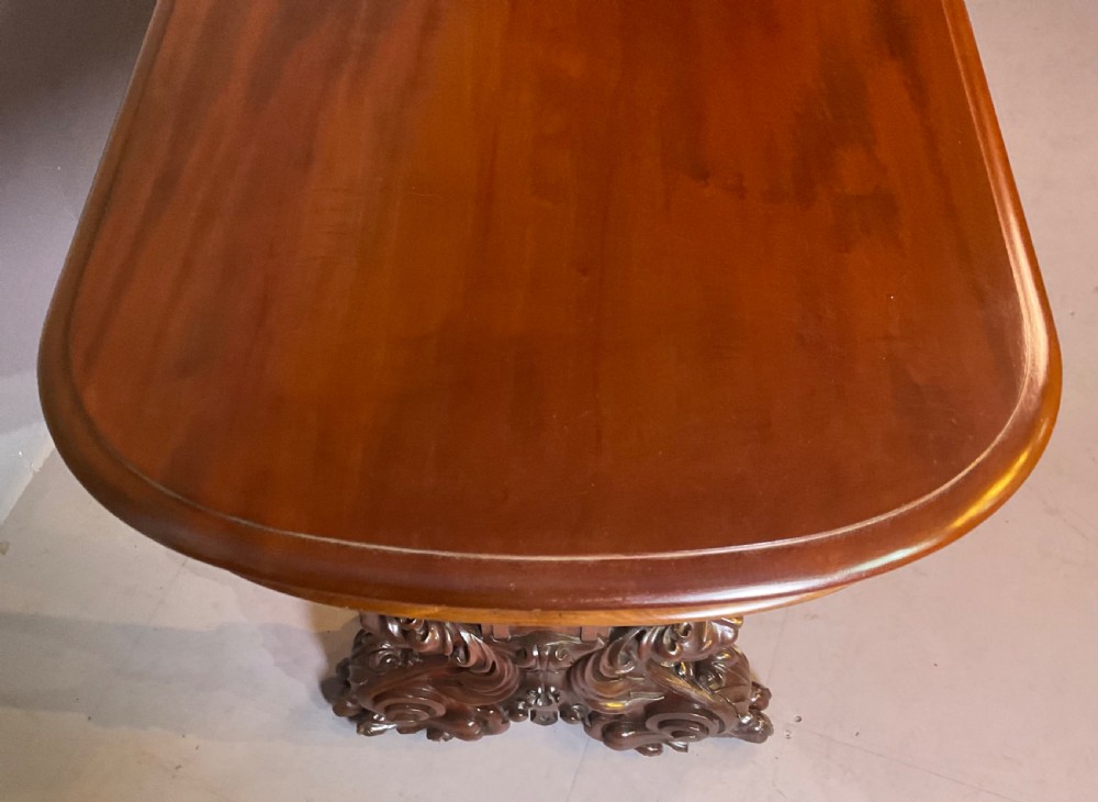 A Victorian three-tiered mahogany metamorphic dumb waiter featuring rounded shelf edges and carved scroll feet. View V