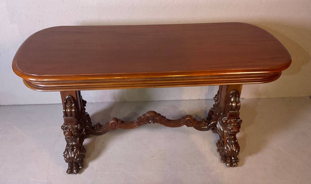 A Victorian three-tiered mahogany metamorphic dumb waiter featuring rounded shelf edges and carved scroll feet. View VI