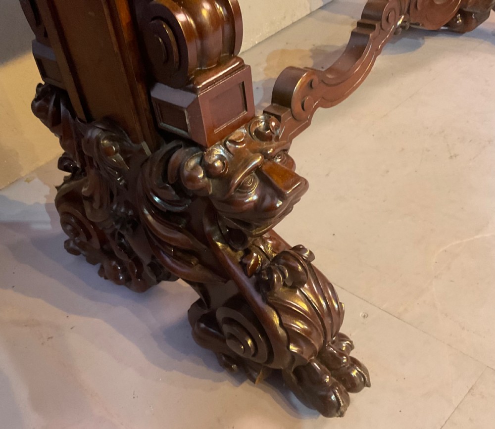 A Victorian three-tiered mahogany metamorphic dumb waiter featuring rounded shelf edges and carved scroll feet. View VII