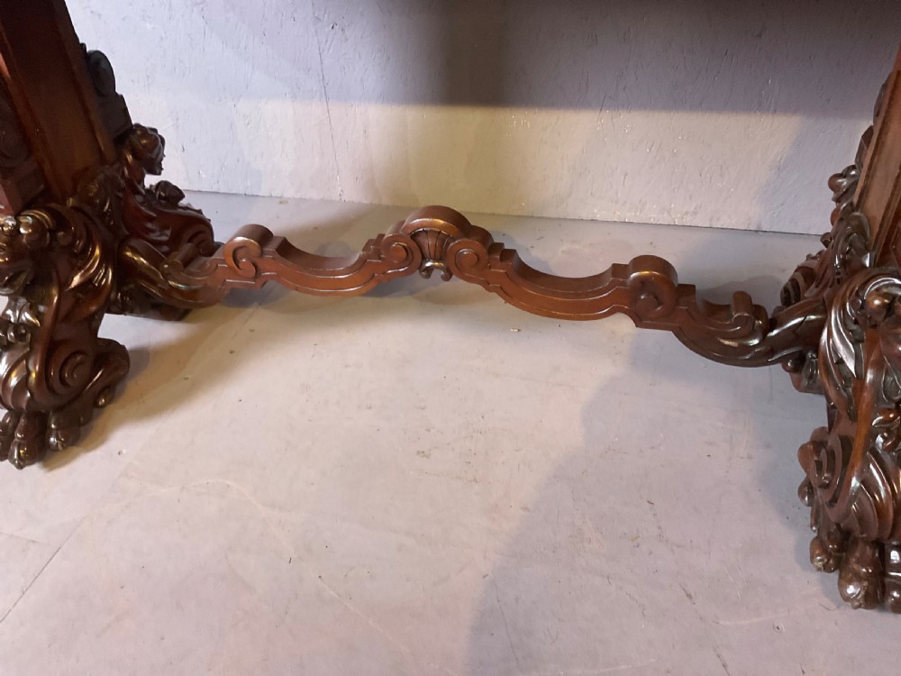 A Victorian three-tiered mahogany metamorphic dumb waiter featuring rounded shelf edges and carved scroll feet. View XI