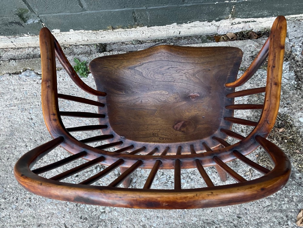 An antique yew wood Windsor armchair featuring a hoop back with vertical spindles, shaped arms, and turned wooden legs. View IV