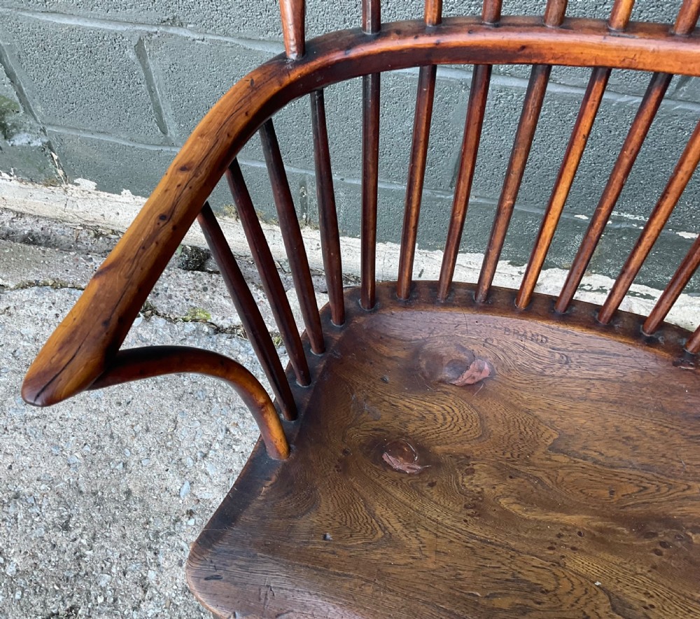 An antique yew wood Windsor armchair featuring a hoop back with vertical spindles, shaped arms, and turned wooden legs. View VI