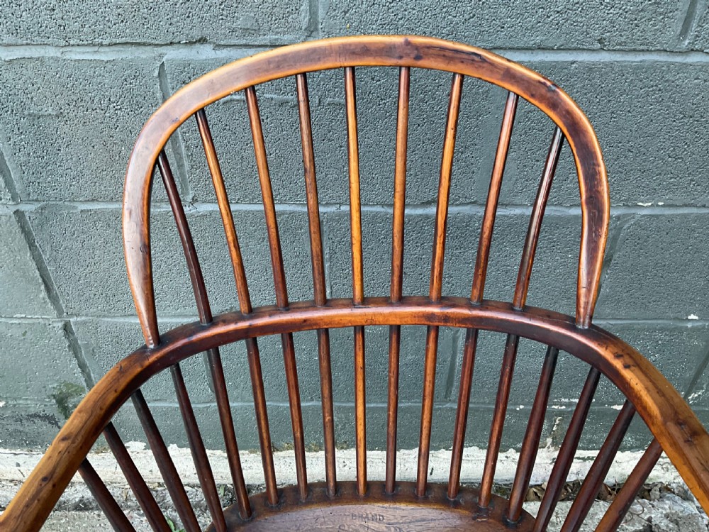 An antique yew wood Windsor armchair featuring a hoop back with vertical spindles, shaped arms, and turned wooden legs. View VII