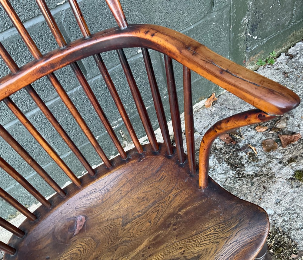 An antique yew wood Windsor armchair featuring a hoop back with vertical spindles, shaped arms, and turned wooden legs. View X