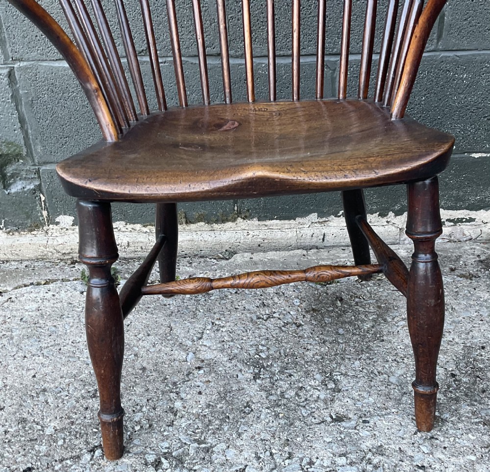 An antique yew wood Windsor armchair featuring a hoop back with vertical spindles, shaped arms, and turned wooden legs. View XII