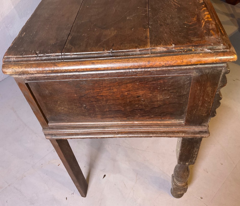A late seventeenth-century dark oak serving dresser featuring three geometric moulded drawers with brass handles and a scalloped lower apron set on turned legs. View VIII