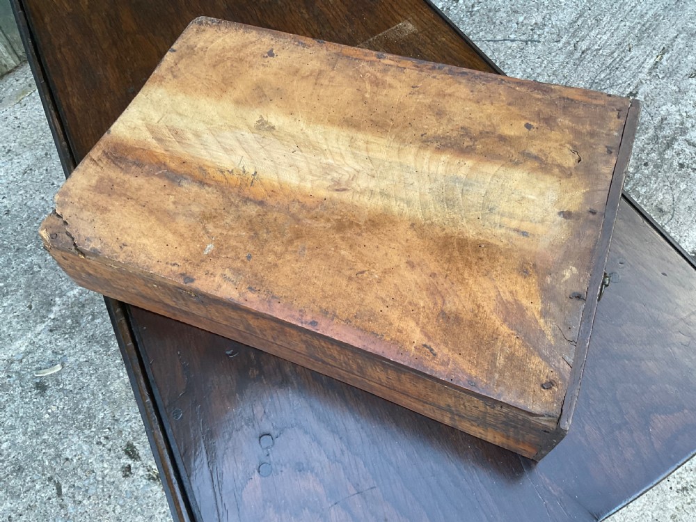 Underside view of a dark brown oak gateleg table showing baluster turned legs, stretchers, hand-forged iron hinges, and hinged drop leaves. View XII