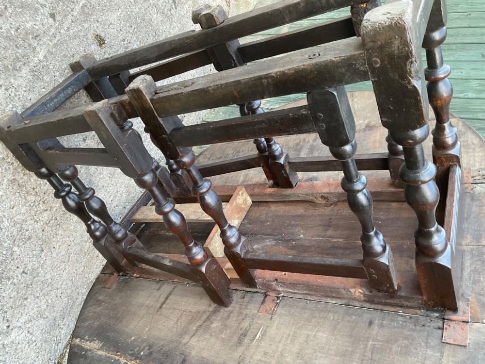 Underside view of a dark brown oak gateleg table showing baluster turned legs, stretchers, hand-forged iron hinges, and hinged drop leaves. View XXIII